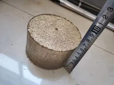 Brass briquette shown with a measuring tape