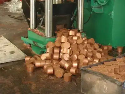 Copper briquettes discharged from a hydraulic press