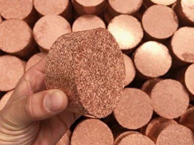 Dense copper chip briquette showing compacted structure