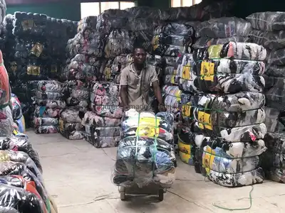 Worker moving a compressed old clothes bale