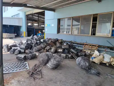 Loose stainless steel wire and sheet scrap beside finished bales