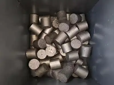 Small cylindrical steel chip briquettes collected after discharge