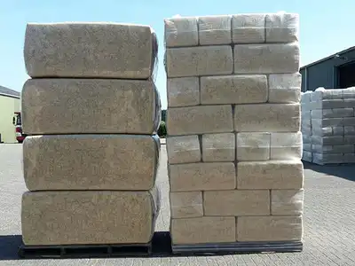 Large and small bagged sawdust bales stacked outdoors