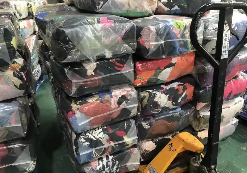 Compressed textile packages stacked beside a pallet truck