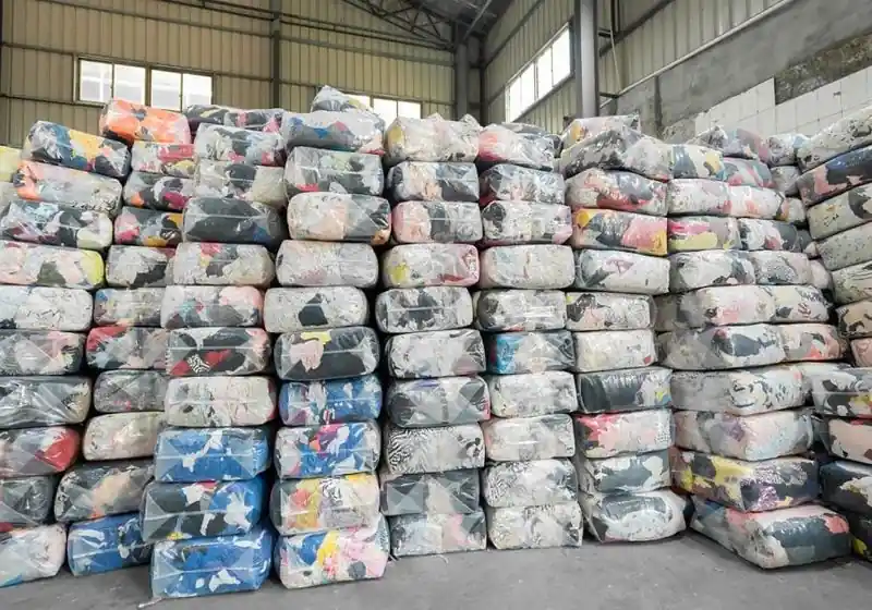Compressed mixed-colour textile packages stacked in a storage area