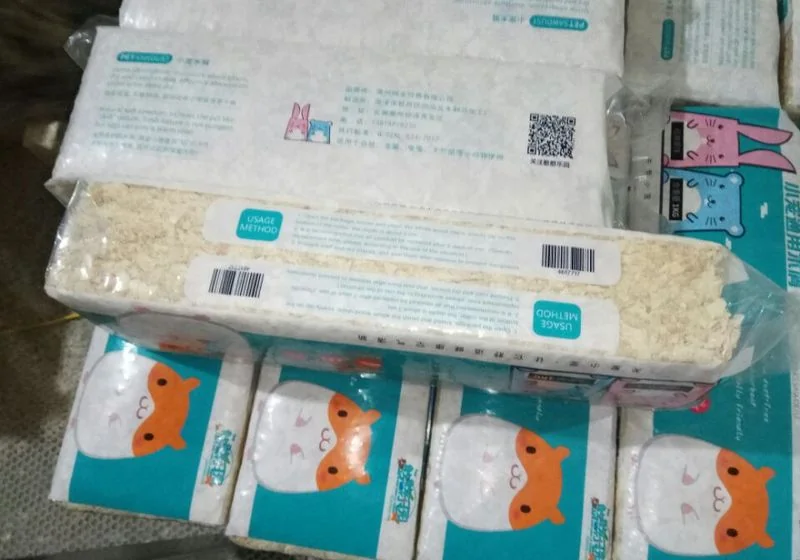 Compressed wood shavings in printed pet bedding bags
