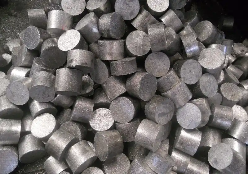 Close-up of collected cylindrical aluminium chip briquettes