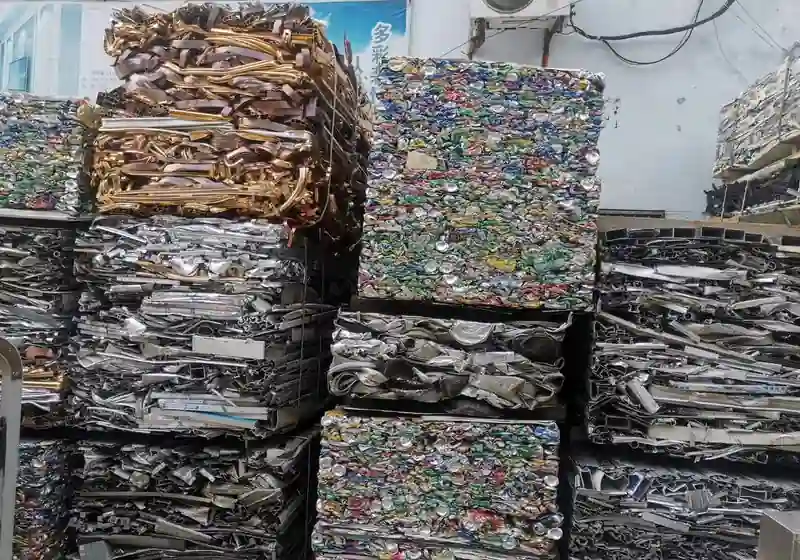 Separate stacks of compressed metal profile bales and aluminium can bales