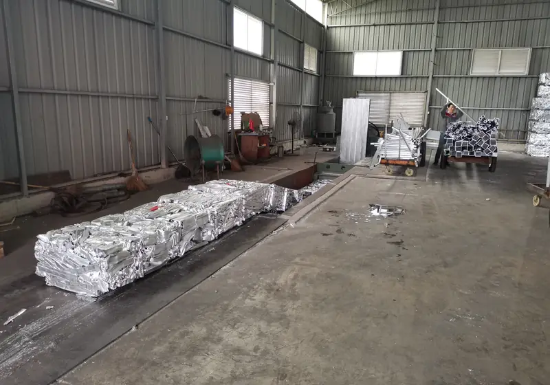Finished aluminium profile packages arranged along the collection area beside loose profiles