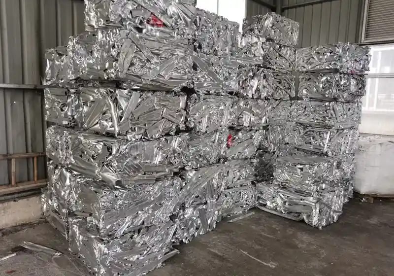 Compressed aluminium profile scrap packages stacked in an indoor storage area