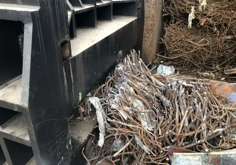 Cut reinforcing bars gathered beside the horizontal container shear discharge opening