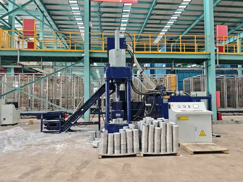 Vertical aluminium chip briquetting press with conveyors and stacked cylindrical briquettes