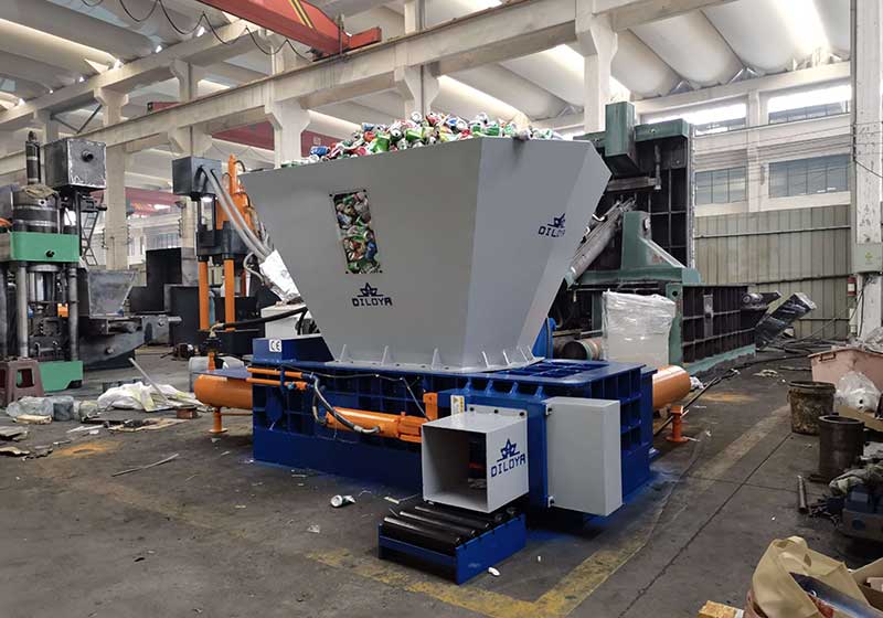 Hopper-fed UBC shear baler with large receiving hopper and discharge chute